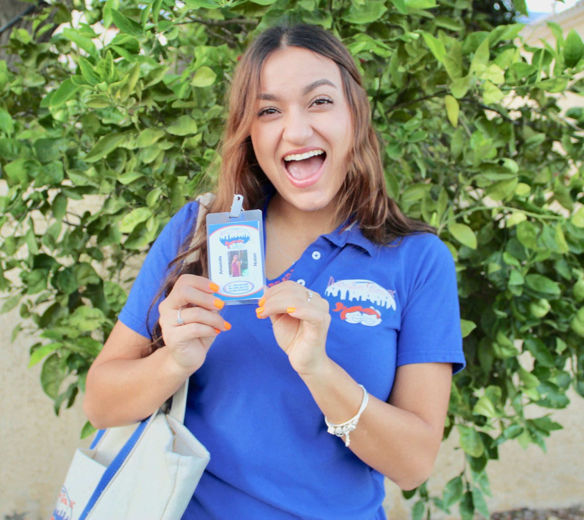 Destination Sitters' babysitter in uniform showing ID Card.