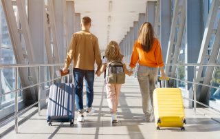 Family_walking_away_at_airport_with_luggage.
